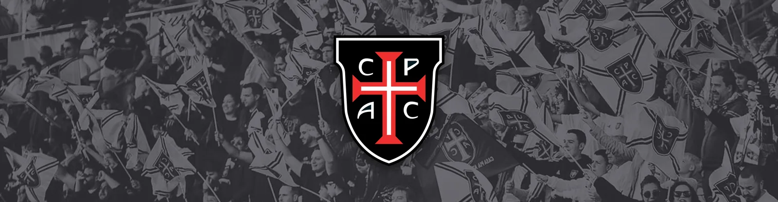Casa Pia AC supporters waving club flags, with the Casa Pia AC crest